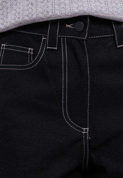 Črne denim hlače z kontrastnim belim šivanjem, z gumbom za zapiranje, zanke za pas in sprednjim žepom na desni strani.