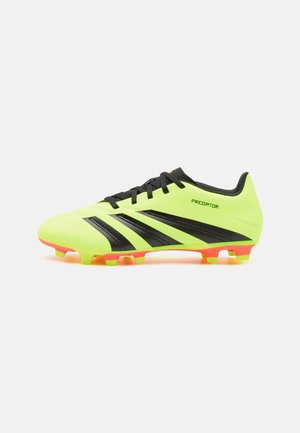 Botín de fútbol en amarillo neón con acentos negros y tres franjas, presentado con un upper texturizado y tachuelas multicolores para tracción.