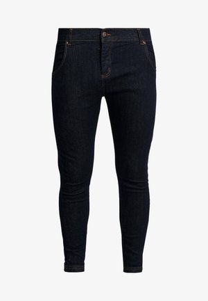 Dunkelblaue Slim-Fit-Jeans mit Fronttaschen, Knopfverschluss und orangefarbenen Nähten vor weißem Hintergrund.