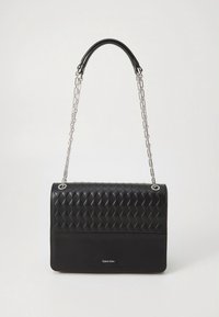 Svart läderhandväska med vävd textur, silverkedjestrap och en slät nedre panel. Har logotypen "Calvin Klein" på framsidan.