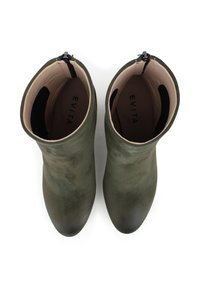 Groene suède enkellaarzen met een gladde textuur, ronde neus en een interne rits; merk zichtbaar op de binnenzool.
