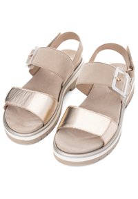 Twee-kleurige sandalen met een gouden metalen band en een beige suède bovenkant, voorzien van een verstelbare gesp, een gevoerde zool en een textured voetbed.