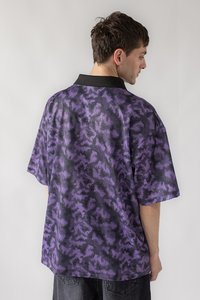 Pernelyg didelė trumpųjų rankovių marškinė juodos ir purpurinės spalvos su tekstūruota geometrine raštu ir vientisa juoda apykakle.