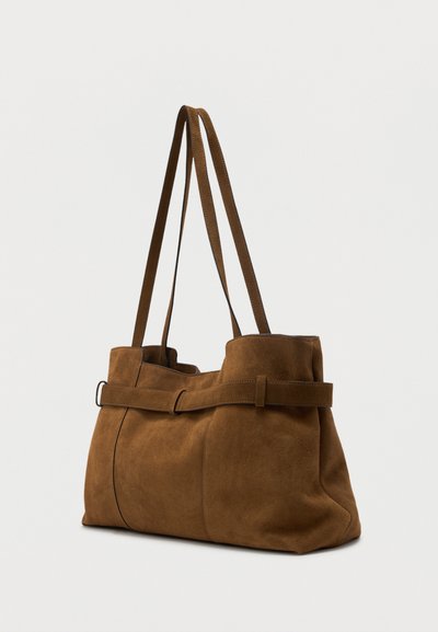 Καφέ τσάντα ώμου από καστόρι με διπλούς ιμάντες και διακοσμητική ζώνη γύρω από το πάνω άκρο, σε όρθια θέση πάνω σε απλό φόντο.