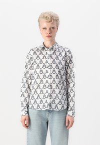 Hvit langermet skjorte med et kontrastfargebundet svart kjede-mønster, krav i kragen, laget av lett stoff.