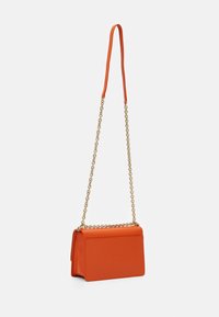 Oranžová rectangulární kabelka se zlatým řetězovým popruhem a oranžovou koženou výztuží na rameno, vystavená na bílém pozadí.