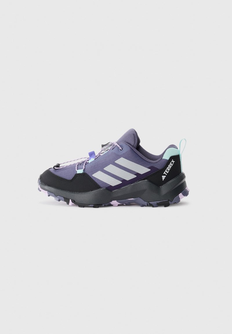 Lila och svarta trailrunning-skor med övre del i mesh, gummisula och reflekterande tre-stripes-design. Har snörning och hälremsa.