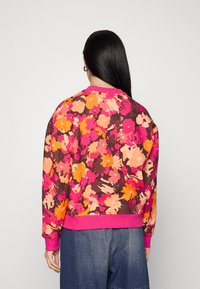Flerfärgad blommönstrad sweatshirt i nyanser av rosa, orange och brunt; har ribbade ärmslut och nederkant; avslappnad passform.