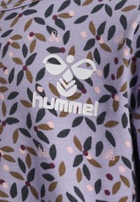 Lila sweatshirt med ett blommönster som har gröna blad, bruna och rosa accenter, samt en vit "hummel"-logotyp på framsidan.