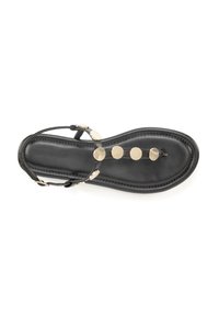 Črne sandale s ravnim podplatom, tankimi trakovi in krožnimi zlatimi poudarki ob zgornjem delu. Gladka usnjena tekstura z minimalnim dizajnom.