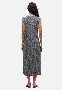 Vestido negro y blanco con estampado, de mangas cortas, corte largo y recto, y una sutil textura de rejilla. Presenta una longitud por debajo de la rodilla.