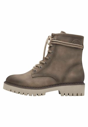 Bottine en cuir marron avec bout rond, semelle en caoutchouc beige et lacets beige. Présente un patch logo sur le côté et une finition texturée.