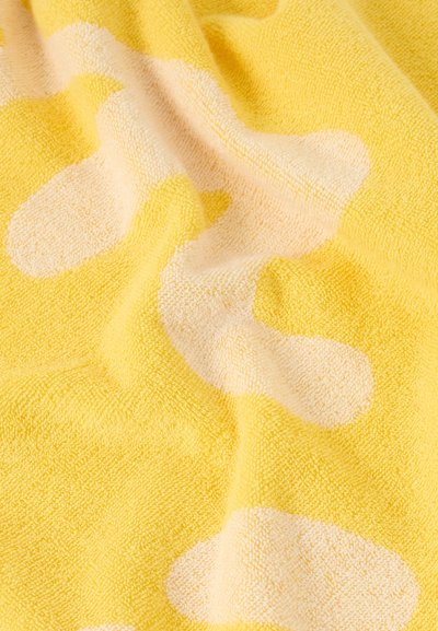 Κίτρινο ύφασμα με απαλή, υφή επιφάνεια, που διαθέτει ακανόνιστα ανοιχτόχρωμα κρεμ αφηρημένα σχήματα και απαλές πτυχώσεις.