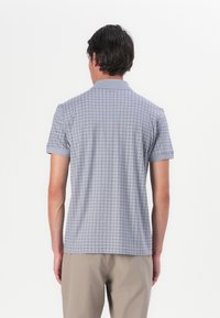 Hellgraues Poloshirt mit kurzen Ärmeln und einem dezenten Karomuster. Verfügt über einen Kragen und umgekrempelte Ärmel, hergestellt aus einem glatten, atmungsaktiven Stoff.