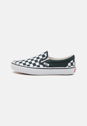Tenis typu slip-on marki Vans z czarno-białym wzorem w szachownicę, białą gumową podeszwą i małą metką z logo po boku.