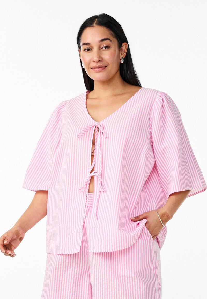 Pink and white striped short-sleeved blouse with a V-neck and tie closure. Fabric appears lightweight with a relaxed fit and soft texture.