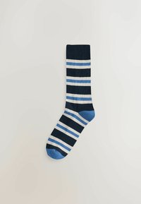 Ein einzelner Socken mit horizontalen Streifen in Marineblau, Hellblau und Weiß, mit einer einfarbigen hellblauen Ferse und Spitze, flach auf einem neutralen Hintergrund ausgelegt.