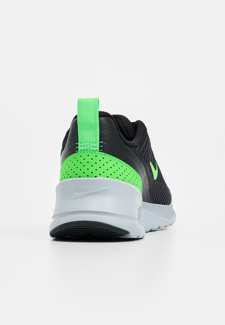 Schwarzer Sportschuh mit neon-grünen Akzenten, strukturierter Oberfläche, gepolstertem Schaft und einer hellgrauen Sohle mit kreisförmigem Profil.