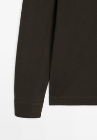 Ciemnobrązowa koszula z długim rękawem wykonana z teksturowanej, tkanej tkaniny. Ma zaokrąglony dół i mankiety ze wzmocnionym szwem.