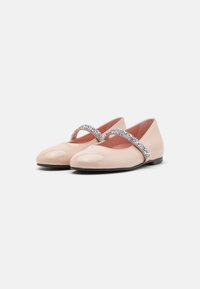 Bailarinas de charol en rosa claro con una cinta de purpurina plateada en la parte superior. Suela baja negra con diseño de punta redonda.