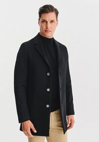 Czarny płaszcz z mieszanki wełny, z dopasowanym krojem, jednorzędowym zapięciem na cztery guziki oraz gładką fakturą.