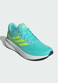Turquoise athletic shoe with green accents, mesh upper, textured surface, and rubber outsole. Features three parallel stripes on the side.