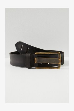 Černý kožený pásek stočený s obdélníkovou sponou z patinované mosazi a několika otvory pro nastavení na bílém povrchu.