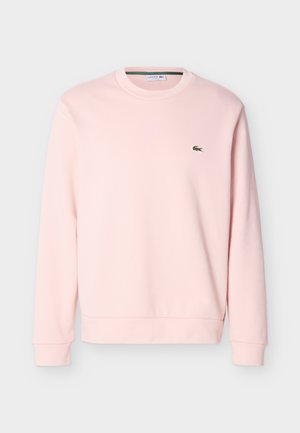 Hellrosa Sweatshirt mit Rundhalsausschnitt, langen Ärmeln und kleinem grünen Lacoste-Krokodil-Logo auf der linken Brust.