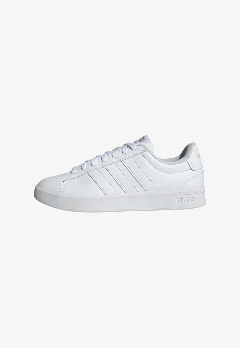 Baskets Adidas blanches basses avec fermeture à lacets, trois bandes latérales et logo embossé sur la semelle et la languette du talon.