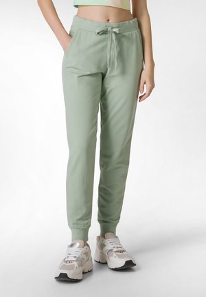 Pantalons jogger vert clair en tissu doux, dotés d'une taille élastique avec cordon de serrage, poches latérales et poignets tapered.