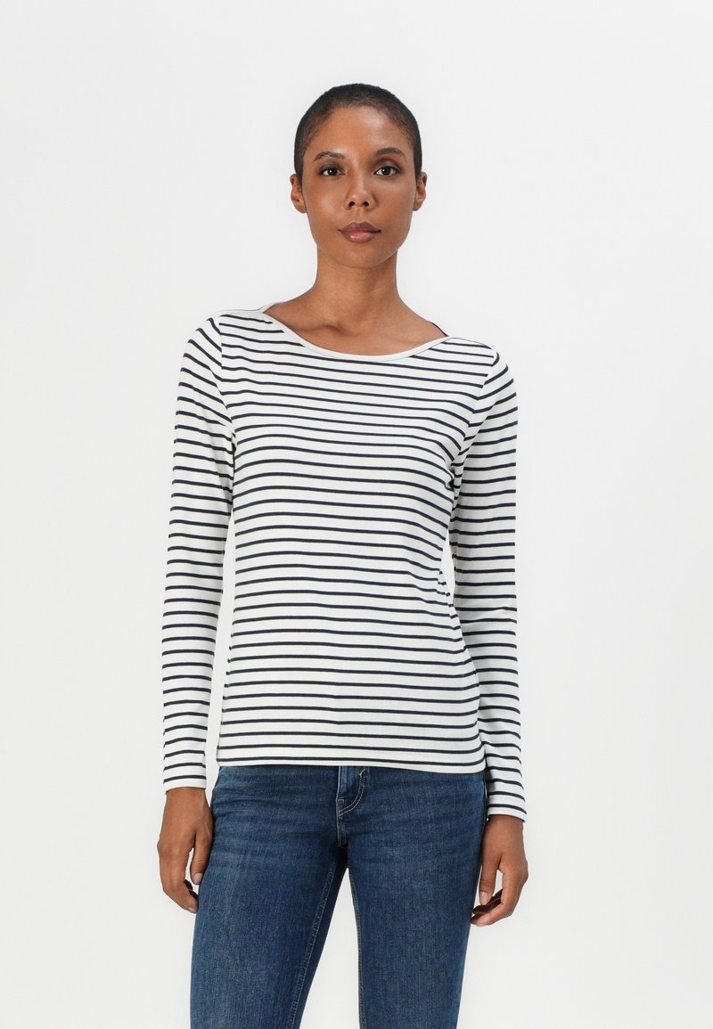 T-shirt à manches longues, col rond, avec des rayures horizontales noir et blanc, fabriqué à partir d'un tissu doux ; associé à un jean en denim bleu.