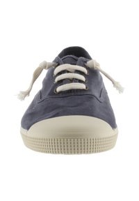 Zapatillas de lona en azul marino con suela de goma beige, puntera redonda y cordones color crema. Textura suave con detalles de diseño mínimos.