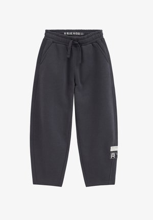 Dunkelgraue Jogginghose mit elastischem Bund, Kordelzug, Seitentaschen und zwei weißen und schwarzen Patches am rechten Bein nahe dem Knie.