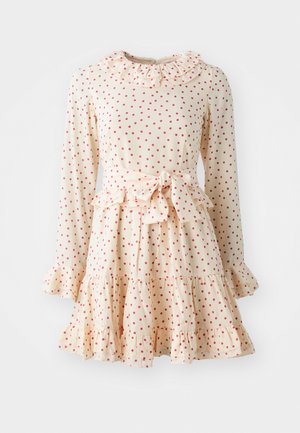 Lichtbeige jurk met rode stippen, lange mouwen, gerimpelde kraag, getailleerde taille met een strik en een gelaagde, uitlopende rok. Zachte stof.
