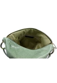 Groene leren handtas met een gestructureerde buitenkant, ritssluiting en een gladde, lichtgekleurde binnenkant met een klein ritsvak.