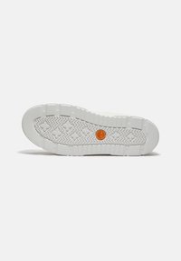 Sole di sneaker bianca con un motivo in gomma testurizzata, caratterizzata da un emblema arancione al centro e una punta leggermente arrotondata.