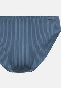 Slip da bagno blu a righe con una superficie liscia. Presenta un'etichetta con logo e una vita elastica. Realizzato in tessuto elastico per costumi da bagno.
