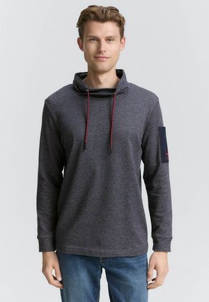 Mørkegrå langærmet skjorte med cowl neck, prydet med røde snore og en blå ærmelap med tekst. Glat tekstur og afslappet pasform.