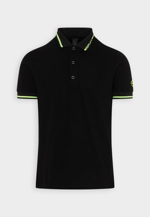 Schwarzes Polohemd mit einem kontrastierenden grünen Kragen und Ärmeldetails. Verfügt über drei Knöpfe und ein Logo-Detail auf dem linken Ärmel.