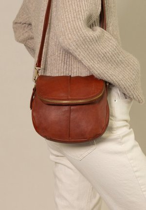 Bruine leren crossbodytas met een afgeronde vorm, ritssluiting en een flap. Kenmerkt zich door een gladde textuur en gouden hardware-accenten.