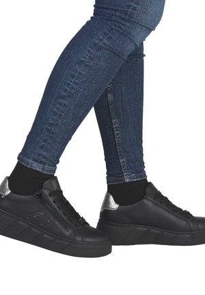 Black sneakers with a textured leather upper, silver heel accents, lace-up closure, and a thick, ridged platform sole. Worn with dark jeans.