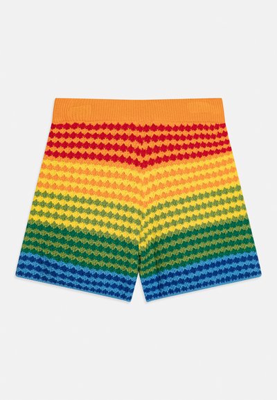 Shorts tricotés avec des rayures horizontales arc-en-ciel en rouge, orange, jaune, vert et bleu avec une ceinture orange sur fond blanc.
