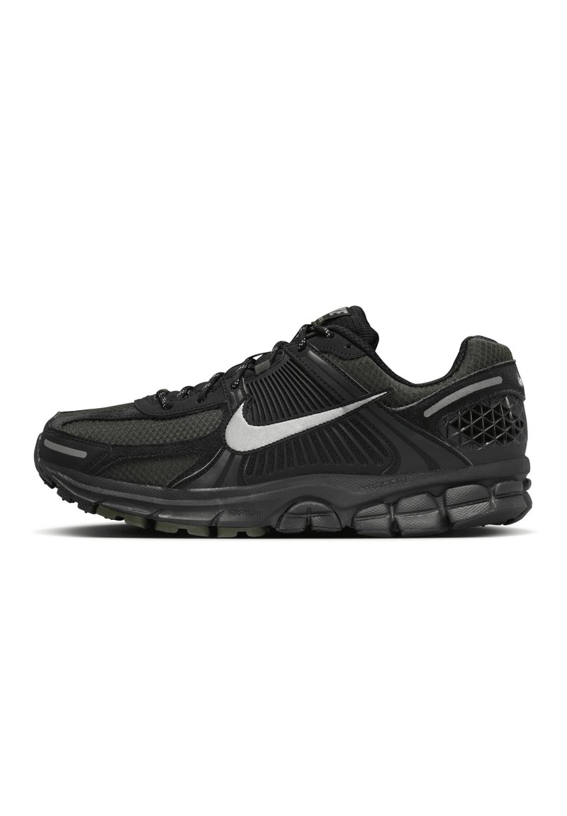 Juoda sportinė avalynė su tekstūrine tinklelio viršutine dalimi, paminkštintu apvadu ir sidabriniu Nike logotipu. Ypatybės: stora guminė pada ir raštuoti akcentai.