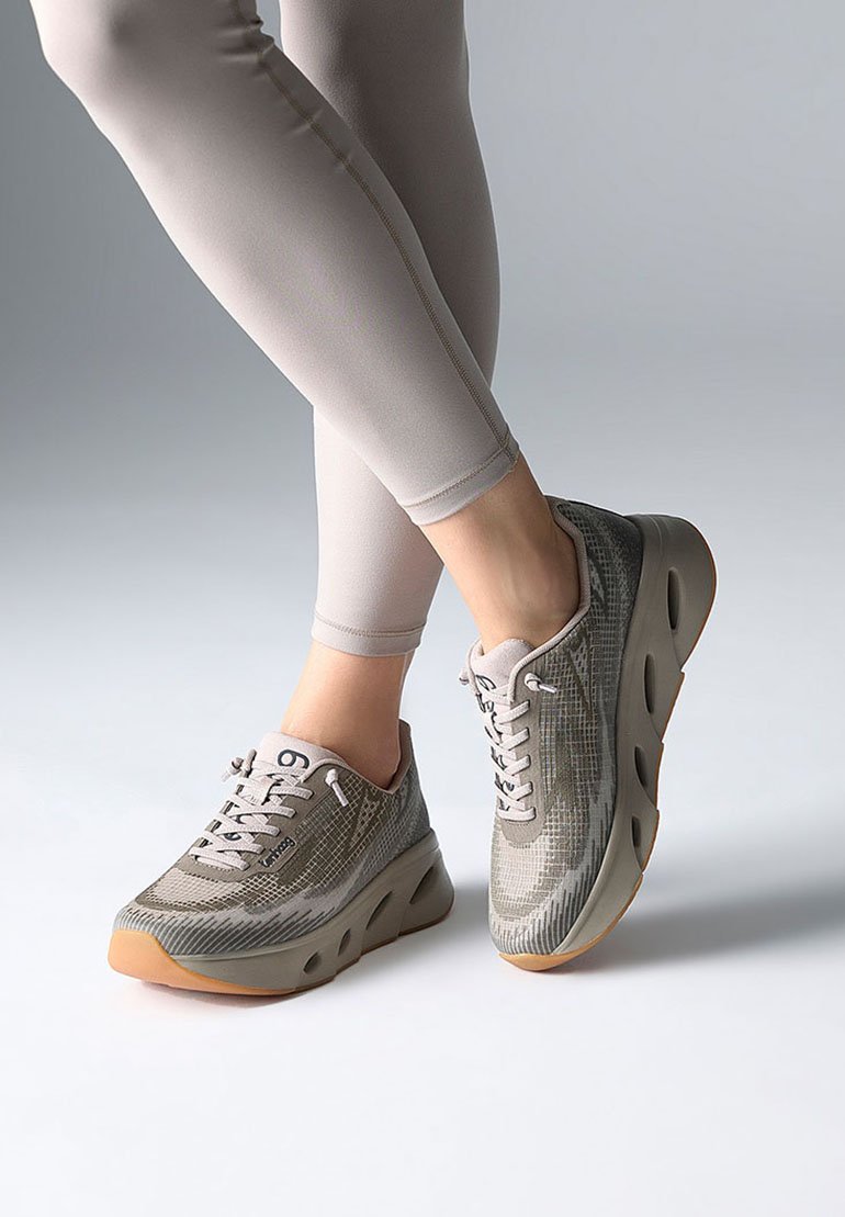 Sportliche Schuhe mit grauem Mesh-Obermaterial und geometrischem Muster, weißen Schnürsenkeln, gepolstertem Sohle und einer hellbraunen Gummisohle.