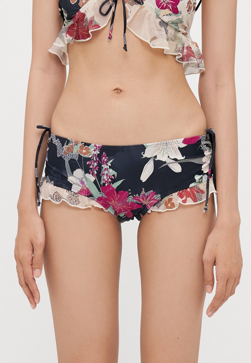 Bikini-set med blomstermønstrete topp med volanger og mørk marinebunn med kontrasterende blonderkant og justerbare bånd.