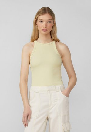 Lichtgele geribbelde tanktop met een hoge halslijn en zonder mouwen, gecombineerd met crèmekleurige, relaxte cargobroek met zijzakken.