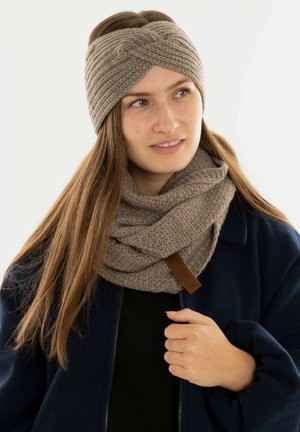Knitted beige headband with twisted design and matching textured scarf, both featuring a leather tag. Soft, cozy material.