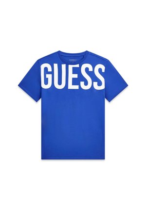Maglietta blu a maniche corte con grande scritta bianca "GUESS" sul petto, scollo rotondo e design semplice e casual.