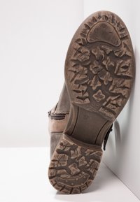 Bruna mockaskinnsanklädda boots med gummisula som har strukturerad mönstring och en sidDragkedja. Storlek 37 synlig på sulan.