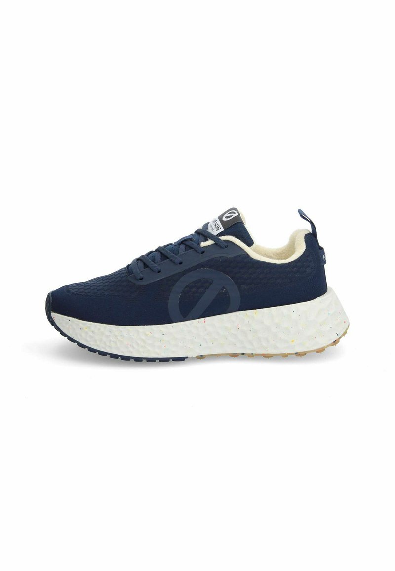 Baskets bleu marine avec une tige texturée, un col crème et une semelle blanche mouchetée multicolore. Elles possèdent des lacets et une étiquette de langue avec une marque.